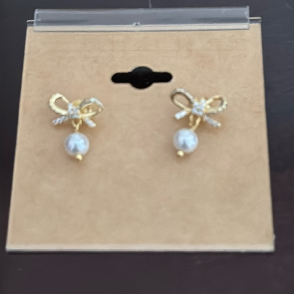 Bow tie and pearl earrings. Super cute. Rubber back. Perfect for a young girl.